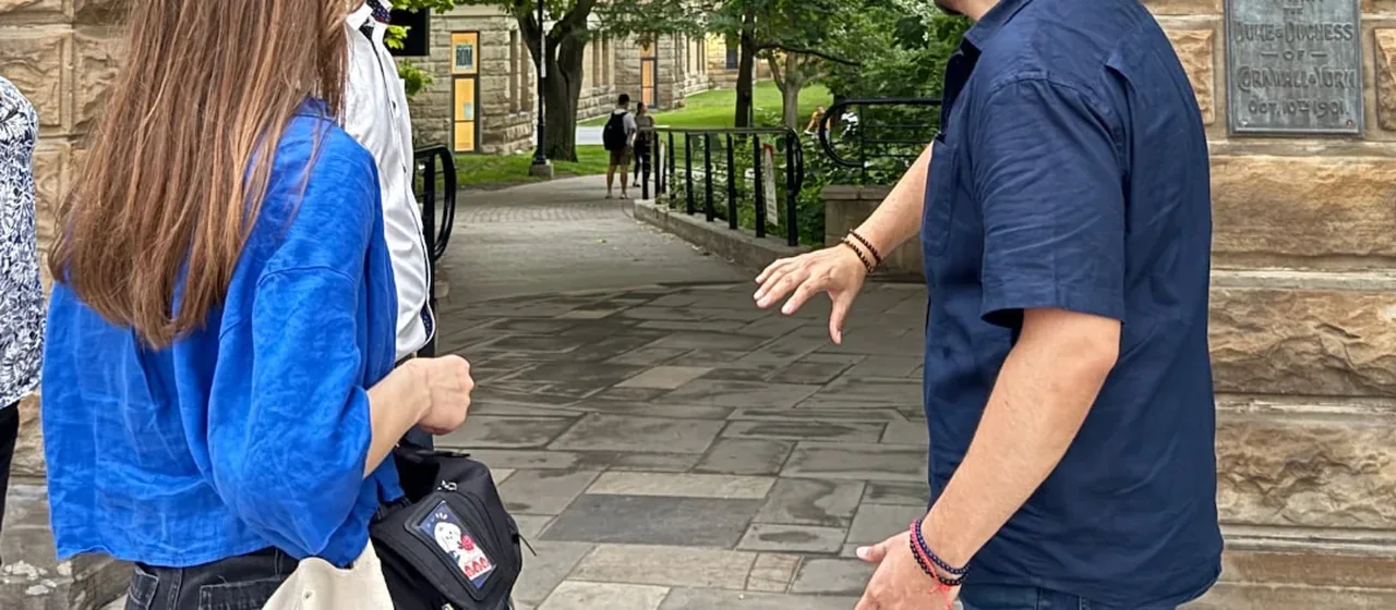 Mike guiding guests beside the stone and iron gates at Philosopher's Walk in Toronto